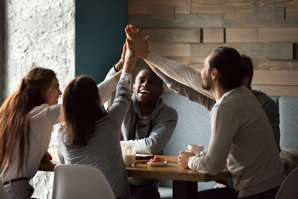 diverse excited best friends giving high five together cafe meeting